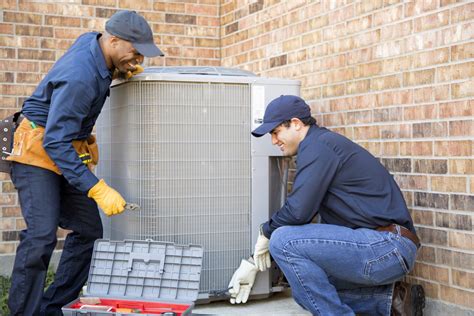 HVAC technicians installing central air conditioner